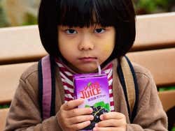 Little girl drinking juice in Hong Kong